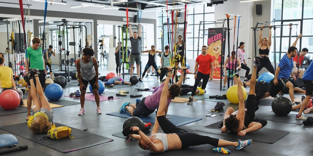 Diverse individuals exercising core strength in a gym.